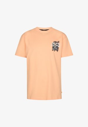 Lyserød ferskenfarvet bomuld T-shirt med korte ærmer og en sort grafik på brystet, kombineret med olivengrønne shorts, hvide sneakers og sokker med sorte striber.