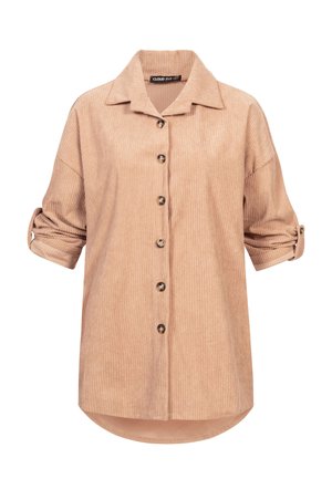 Beige cordfløyelskjorte med krage, knappestolpe foran og oppbrettede ermer. Har vertikale riller og rundet kant med en litt lengre bakside.