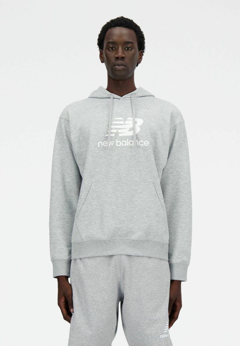 Szary sweatshirt z kapturem, przednią kieszenią i białym logo "New Balance". Materiał wydaje się miękki i teksturowany, z ribbowanymi mankietami i dołem.