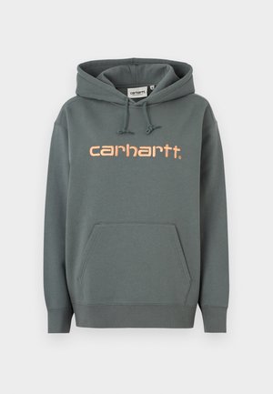 Duks s kapuljačom u tamno sivoj boji, s džepom na prednjoj strani, rebrastim manžetnama i ružičastim logom "carhartt" na prsima. Kapuljača s podesivim vezicama.