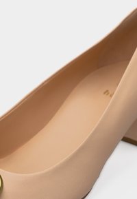 Beežid naiste plokkkontsaga jalanõud ümarate varvaste ja sileda mati viimistlusega, esiosal väike kuldne detail.