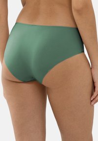 Culotte verte taille haute avec une texture lisse, des bords sans couture et une finition mate. Le design couvre les hanches et offre une couverture complète à l'arrière.