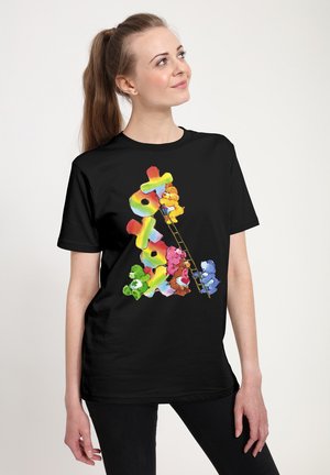 Sort t-shirt med farverige tegneserie-bjørne i forskellige farver, der klatrer op ad en stige, med lyse, levende grafikker og et legende design.