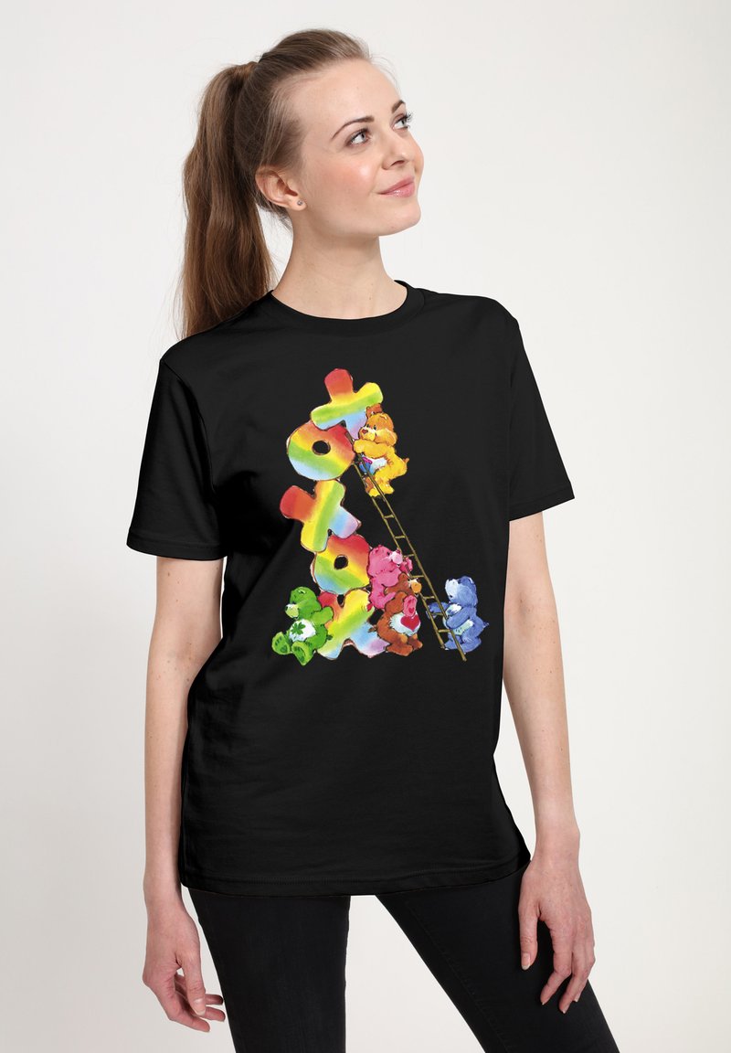 Černé tričko s barevnými kreslenými medvědy v různých barvách, jak šplhají po žebříku, s jasnou, živou grafikou a hravým designem.