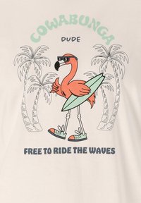 Grafisk t-shirt med en orange flamingo som bär solglasögon, håller i en grön surfbräda, omgiven av palmer och text nedanför.