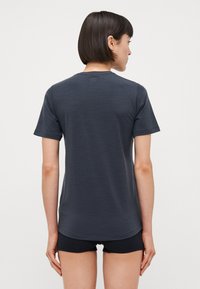 Gray short-sleeve t-shirt made from a textured fabric, featuring a rounded neckline and a relaxed fit, shown from the back.
