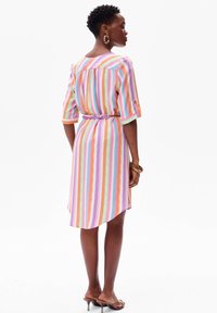 Wielokolorowa sukienka w paski z krótkimi rękawami, elastycznym pasem i zaokrąglonym dołem. Wykonana z lekkiego materiału; posiada fioletowe, różowe, zielone i pomarańczowe paski.