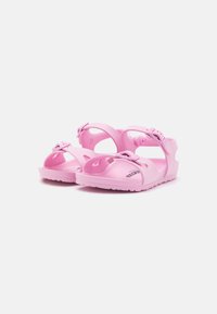 Pink sandals made of durable rubber, featuring adjustable straps, a textured sole, and cut-out details for breathability.