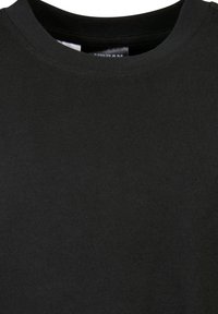 Črna majica z okroglim izrezom iz mehke, tesno tkanine z vidnimi šivi okoli ovratnika.