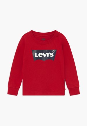 Czerwona dziecięca koszulka z długim rękawem z granatowym logo Levi's na środku klatki piersiowej oraz ściągaczami na rękawach.