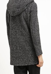 Cappotto grigio con cappuccio realizzato in materiale testurizzato, caratterizzato da un design morbido e un taglio midi, con un sottile motivo a macchie.