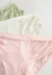 Drie paar damesondergoed in lichtgroen, wit en roze. Elk stuk heeft kanten randafwerking en vertoont bloemmotieven langs de randen.