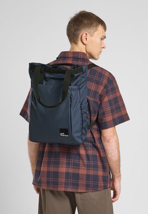 Zaino blu navy con dettagli neri, dotato di manici doppi, tasca laterale e logo. Tessuto texturizzato, forma rettangolare, design moderno.