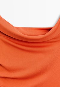 Oranges Oberteil aus glattem Stoff, mit einem drapierten Ausschnitt und weicher Textur. Das Design ist schlicht und ohne sichtbare Muster oder Verzierungen.