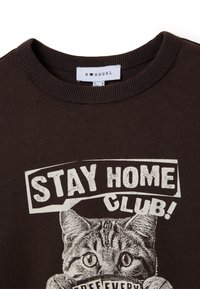 Sudadera marrón con cuello redondo acanalado, que presenta un gráfico de un gato con el texto "¡QUÉDATE EN CASA CLUB!" en letras blancas desgastadas.
