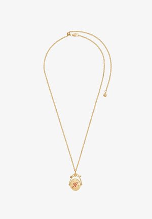 Õrn kuldse ketiga kaelakee ovaalse medalljoni ripatsiga, millele on graveeritud punane täht "N" ja väikesed tähekujundid.