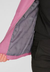 Roze leren jas met grijze voering. De binnenstof heeft een herhalend logo-patroon. Ritsluiting langs de naad.