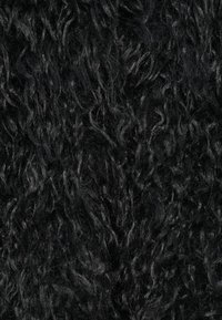 Tissu noir texturé avec une surface moelleuse et duveteuse, présentant des fibres ondulées variées et une structure dense, créant profondeur et intérêt visuel.