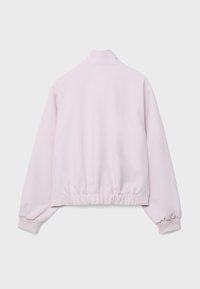 Světle růžová fleecová bunda s dlouhými rukávy, vysokým límcem a elastickými manžetami a lemem, zobrazená zezadu na jednobarevném pozadí.