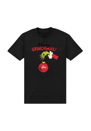 Černé tričko se zelenou rukou Grinche, která drží červenou vánoční ozdobu s nápisem "The Grinch" a nad ní je text "Merry GRINCHMAS!".