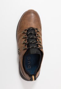 Baskets en cuir marron avec lacets noirs et œillets métalliques. Dotées d'un col rembourré noir et d'une semelle intérieure bleue avec logo. Semelle texturée.