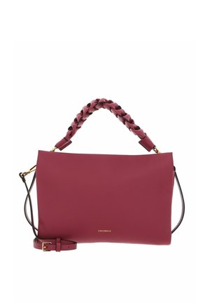 Sac à main en cuir bordeaux avec poignée tressée sur le dessus, bandoulière amovible et petit logo doré « Coccinelle » au centre devant.