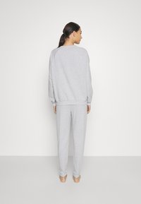 Grijs katoenen sweatshirt en bijpassende sweatpants, met een relaxte pasvorm, ribgebreide mouwen en zonder zichtbare patronen of logo's.