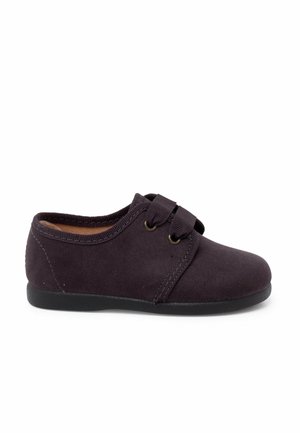 Scarpa in tela viola con punta arrotondata, doppie cinghie elastiche e suola nera in gomma bassa. Texture morbida e design minimalista.