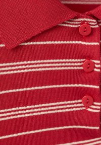 Chemise en maille rouge avec des rayures horizontales blanches, des boutons rouges et un col plié.