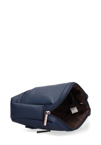 Borsa in pelle textured blu navy con zip aperta, che mostra l'interno in tessuto scuro e l'etichetta di cura all'interno.