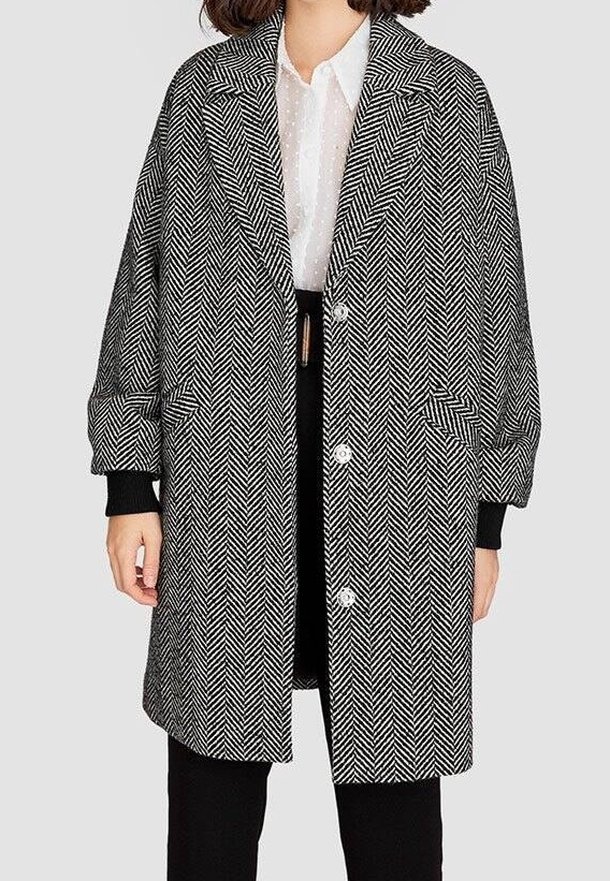 Haringbone-patroon jasje in zwart en wit, met een geknipt kraag, oversized pasvorm en twee voorzakken met knoopsluiting.