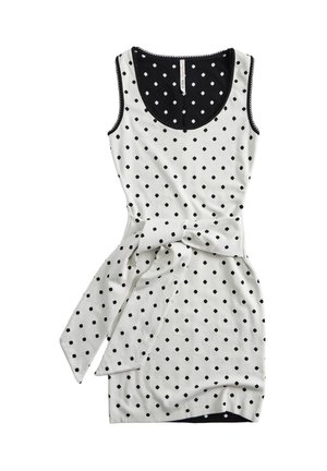 Robe blanche sans manches avec des pois noirs, un col bordé de noir et une ceinture en tissu assortie nouée à la taille.
