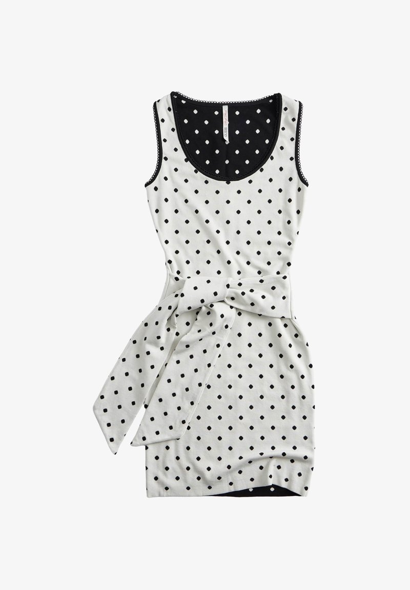 Robe blanche sans manches avec des pois noirs, un col bordé de noir et une ceinture en tissu assortie nouée à la taille.