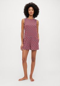 Raudonas ir baltas raštuotas be rankovių rompers, turintis apvalų kaklą, laisvą siluetą ir šonines kišenes. Lygus audinys, lengvas tekstūros.