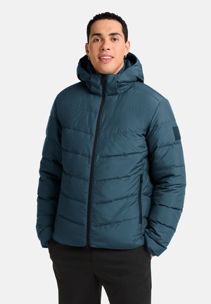 Veste doudoune teal avec capuche, fermeture éclair et design matelassé horizontal. Comprend des poches latérales et un accent noir sur la manche.