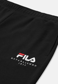 Schwarze Sweatpants mit elastischem Bund, ausgestattet mit dem gestickten "FILA"-Logo in Weiß und Rot sowie dem Text "ESTABLISHED 1911" am Unterschenkel.