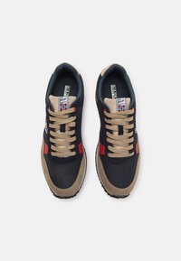 Sneaker blu navy e beige con una punta in suede marrone chiaro, dettagli rossi e lacci beige, suola in gomma nera testurizzata.