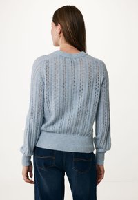 Světle modrý pletený svetr s vertikálními otvorovými pruhy, ribovaným lemem a balónovými rukávy. Texturovaná látka doplňuje ležérní design.