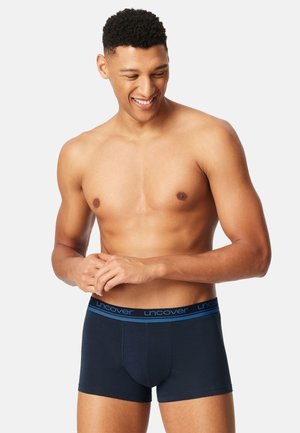 Navy boxer briefs with a snug fit, made from soft cotton, featuring a blue elastic waistband with the brand name "uncover" printed.