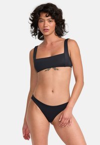 Ensemble de bikini noir comprenant un haut à encolure carrée avec des bretelles larges et un bas taille basse, fabriqué en tissu lisse, conçu pour le confort.