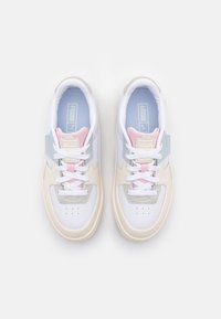 Baskets blanches et grises avec des accents roses et bleus, présentant un dessus en tissu lisse, un système de laçage et un détail perforé au niveau des orteils.