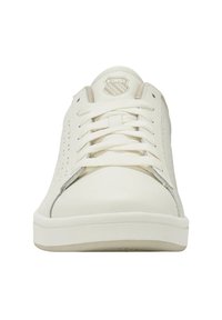 Zapatilla blanca con lados perforados, cordones planos y puntera redonda. Cuenta con un logo en la lengüeta y una suela de goma texturizada.