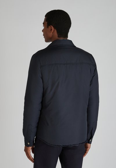Giacca imbottita blu navy con un collo a revers, polsini abbottonati e una finitura liscia. Presenta un dettaglio sullo yoke posteriore.
