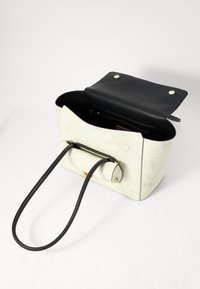 Sac à main texturé vert clair avec un intérieur noir et des doubles poignées, doté d'une fermeture à rabat et de quincaillerie en accent doré.