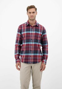 Rot und blau kariertes Hemd mit langen Ärmeln, mit kontrastierenden Linien und einer Brusttasche, getragen mit hellen Khakihosen.