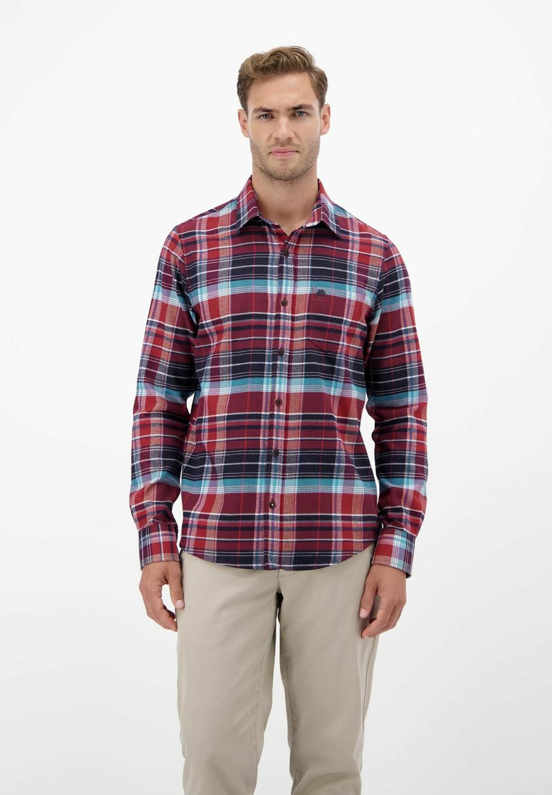 Rot und blau kariertes Hemd mit langen Ärmeln, mit kontrastierenden Linien und einer Brusttasche, getragen mit hellen Khakihosen.
