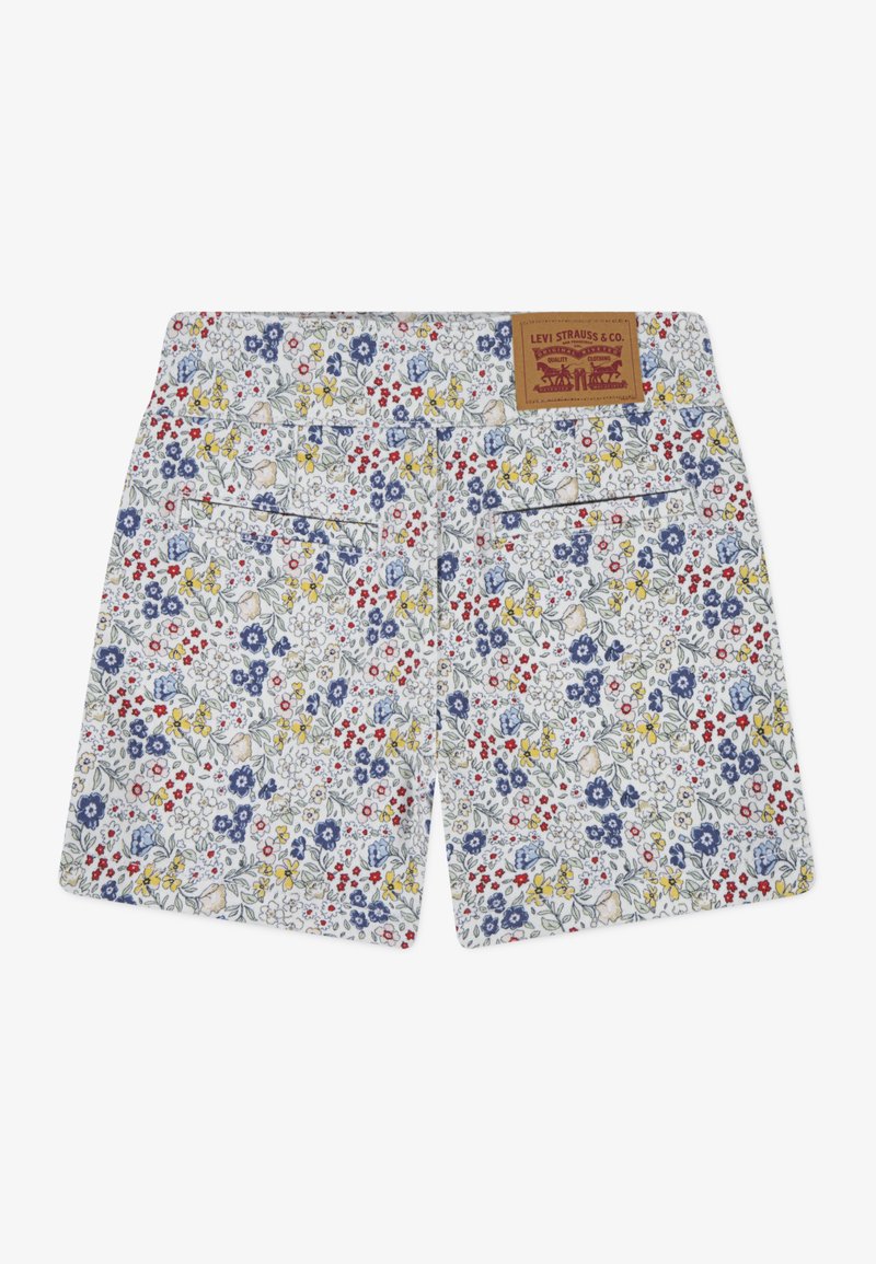 Shorts à imprimé floral avec un fond blanc et des fleurs bleues, rouges et jaunes, deux poches arrière et une étiquette en cuir brun avec logo.