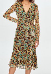 Langärmliges, V-Ausschnitt-Kleid aus transparenter Stoff mit einem bunten, spiralförmigen Muster in Braun, Grün und Orange. Es verfügt über eine gebundene Taille und einen geschichteten Saum.
