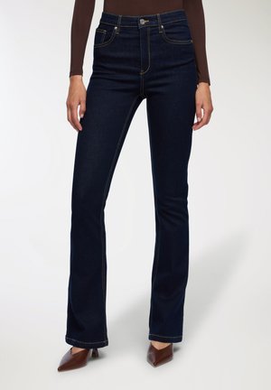 Jeans svasati di colore blu scuro in denim, con cuciture a contrasto, design a cinque tasche e chiusura frontale con bottone.