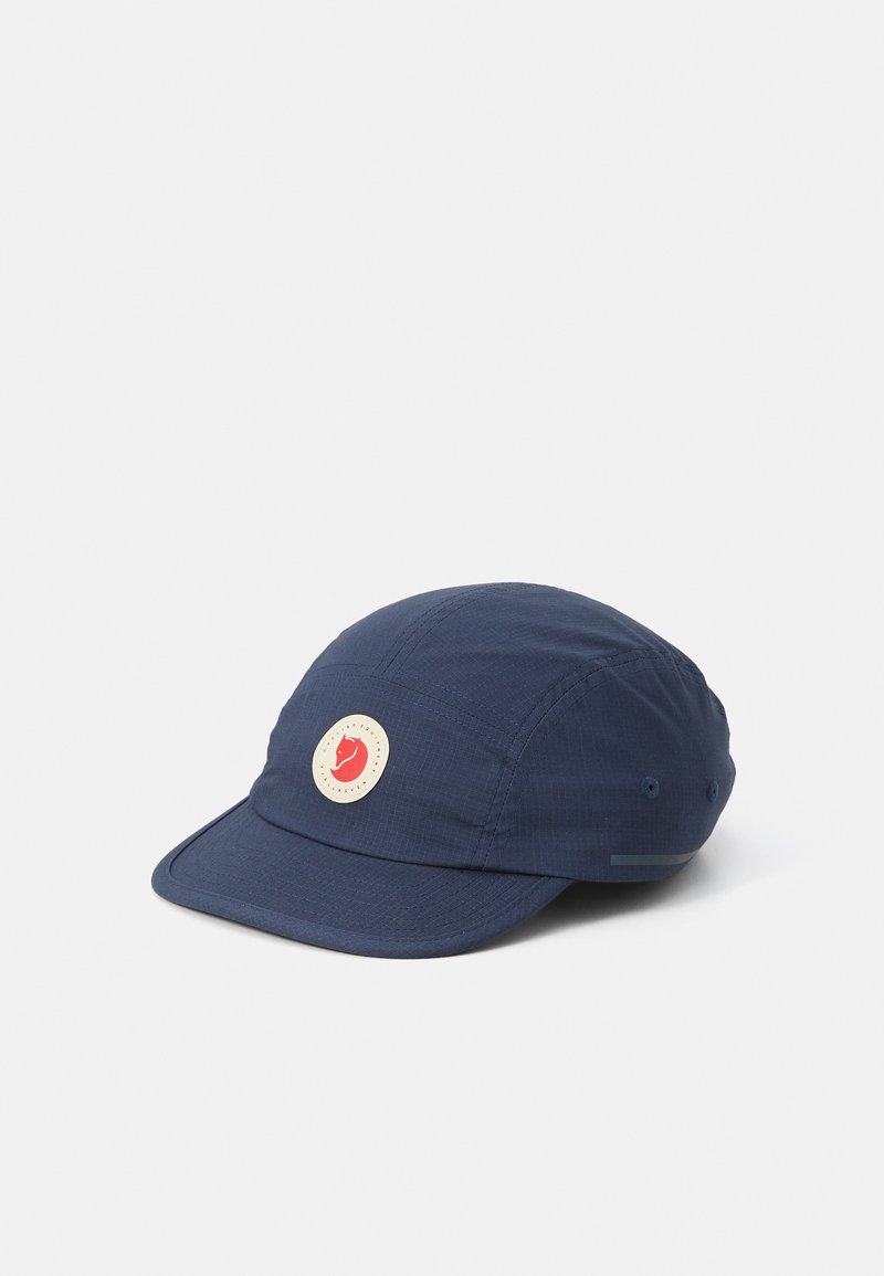 Chapéu azul com um emblema redondo apresentando um design vermelho. Feito de material leve, com uma aba padrão e superfície texturizada.